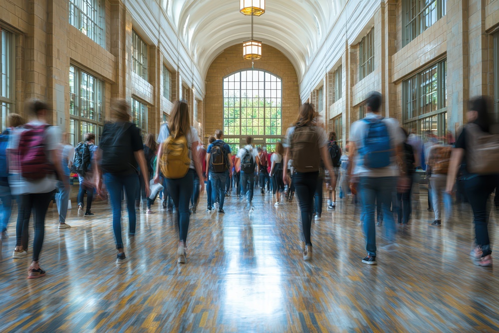 High school students in busy college building with motion blur between lessons